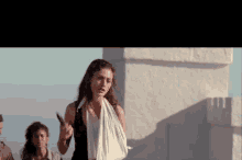 a woman with a bandage on her arm holds a knife in her hand