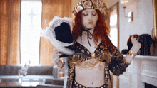 a woman with red hair is wearing a costume and holding a black hat