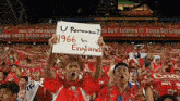 a fan holds up a sign that says 1966 in england