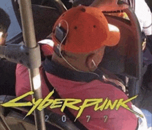 a man wearing headphones is sitting on a bus with a cyberpunk 2077 logo in the background