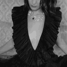 a black and white photo of a woman wearing a black dress