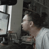 a man wearing glasses is looking at a computer screen that says samsung on it