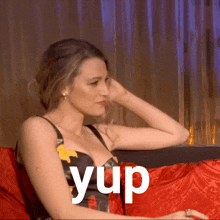 a woman is sitting on a couch with the word yup written on the bottom