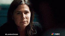 a woman in a dark room with a nbc logo in the corner