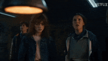 a group of people are standing in a dark room with a netflix logo in the background