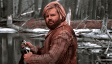 a man in a plaid shirt is holding a fishing rod