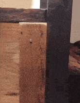 a piece of wood with a screw in it is next to a bed