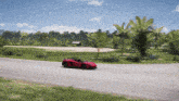 a red sports car is driving down a curvy road