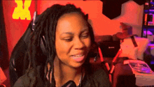 a woman with dreadlocks is sitting in a chair with headphones on .