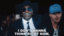 a man wearing a cowboy hat and sunglasses says i don 't wanna think right now