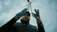 a man wearing gloves with the letter t on them