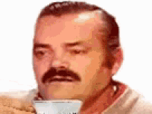 a man with a mustache is holding a cup of coffee in his mouth .