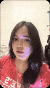 a woman wearing a red shirt with the letters ee2 on it