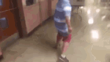 a young boy is walking down a hallway in a hospital .
