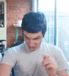 a man in a white shirt is making a face