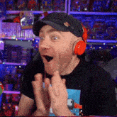 a man wearing headphones and a hat is making a surprised face