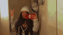 a woman is taking a picture of herself in a bathroom mirror