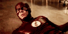 a close up of a man in a flash costume laying on the floor .