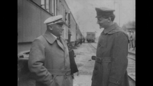 two men in military uniforms are standing next to each other and talking