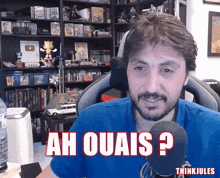 a man sitting in front of a microphone with ah ouais written on his face