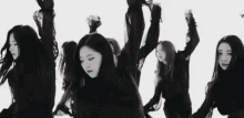 a black and white photo of a group of women dancing together .