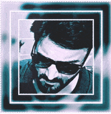 a man with a beard wearing sunglasses and a black shirt