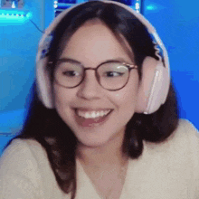 a close up of a woman wearing headphones and glasses .