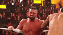 two men are wrestling in a ring and one of them is making a funny face