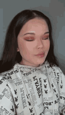 a woman wearing a white hoodie that says ' bityabox ' on it