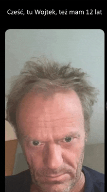 a man with a beard and messy hair looks at the camera with a caption that says czesc