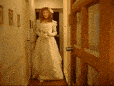 a woman in a wedding dress is standing in a hallway