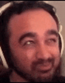 a close up of a man wearing headphones and making a funny face .