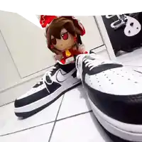 a stuffed doll is sitting on a pair of nike shoes