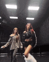 two women are dancing in a dark room