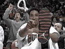a man in a bulls jersey is pointing at a shoe