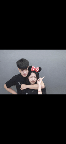 a boy and a girl are posing for a picture with the girl wearing minnie mouse ears