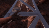 a person 's hand is reaching for a piece of wood in a video game