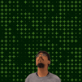a man stands in front of a green background with the number 9