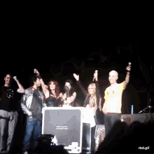 a group of people on a stage with a man in a yellow shirt holding a microphone