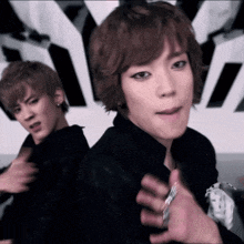 two young men are standing next to each other and one is wearing a ring on his finger