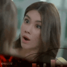 a woman with a surprised look on her face is talking to another woman in a room .