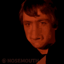 a close up of a man 's face with a big nose in the dark .
