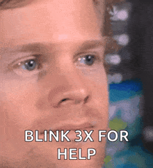a close up of a man 's face with the words blink 3x for help on it
