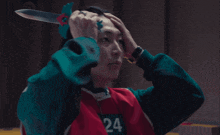 a man wearing a red vest with the number 24