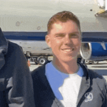 a man wearing a jacket with the letter d on it smiles