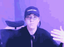 a man wearing a blue hat with the word yt on it is sitting in a chair .