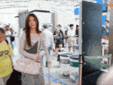 a woman in a white purse is walking through a crowded airport