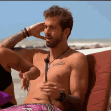 a shirtless man has a tattoo on his chest that says ' mektop ' on it