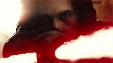 a close up of a person 's face with a red light behind him .