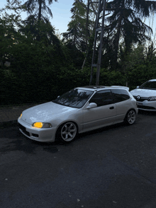 a white car with yellow headlights is parked next to another car